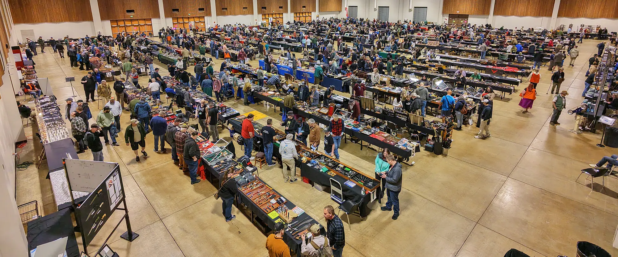 The hall at the 2026 Oregon Knife Show seen from above: long rows of tables and a crowd of visitors